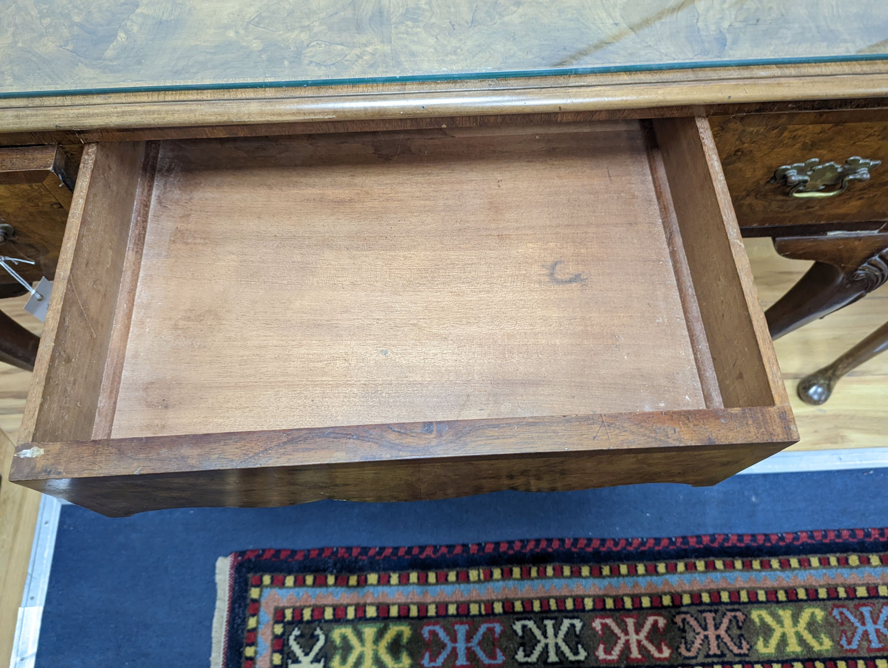 A 1920's Queen Anne revival walnut kneehole dressing table, length 106cm, depth 50cm, height 77cm